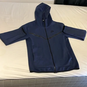 Blå hoodie från Nike med dragkedja - Säljer nu denna fina nike tech koftan i mörkblå! Den har använts ett par gånger, den är i mycket bra skick och passformen är mycket bra. Hör gärna av er med bud och fråga gärna om fler bilder osv!