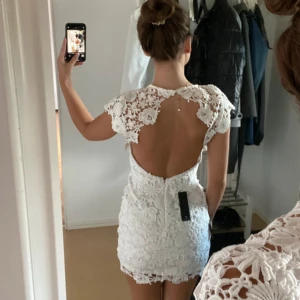 Student/Examensklänning  - Helt ny vit klänning från Lulus. Helt nytt skick, endast testad på två gånger! Passar perfekt till studenten eller examen eller bara en fin sommarkväll ☺️ Virkad vit med öppen rygg! nypris 855 men priset kan absolut diskuteras!