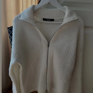 Vit stickad kofta med dragkedja från BIKBOK - Mysig vit stickad kofta från BIKBOK.