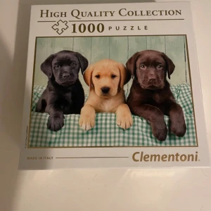 High Quality Collection 1000-bitarspussel med hundvalpar - Säljer ett 1000-bitarspussel från Clementoni med motiv av tre söta hundvalpar på en grönrutigt filt. Perfekt för dig som gillar utmanande pussel och djurmotiv. Tillverkat i Italien.