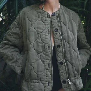 Olivgrön quiltad jacka - Säljer denna virala Zara olivgrön quiltad jacka med rund halsringning och både dragkedja och knappar framtill. Snygg och trendig modell som passar till många outfits. Vid eventuella frågor är det bara att höra av sig! Nypris 859🤩