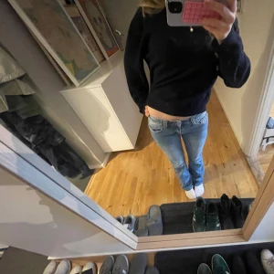 Blå bootcut jeans - Säljer ett par klassiska blå bootcut jeans med normal passform och låg midja. Jeansen har en enkel design utan synliga detaljer och är perfekta för en avslappnad stil. Jag är 160 för referens! Midjemått är 37cm