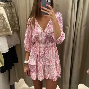 Rosa och vit kortklänning med volang Zara - Superfin kortklänning i rosa och vitt med volangdetaljer och v-ringning. Klänningen är från Zara och helt slutsåld på hemsidan. 💞 Perfekt för sommarens alla tillfällen! Skriv om du har fler frågor!