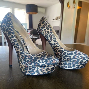 Leopardmönstrade pumps från have2have - Säljer ett par snygga pumps med leopardmönster från have2have. Skorna har hög klack och plattform framtill, rund tå och ovandel i syntetmaterial. Perfekta för dig som vill sticka ut med ett djurmönstrat statement.