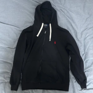 Svart zip up hoodie från Polo Ralph Lauren Medium/Small - Säljer en svart zip up hoodie från Polo Ralph Lauren. Perfekt för en avslappnad stil och enkel att matcha med det mesta. Knappt använd nästan som ny. Storlek Medium men passar också Small