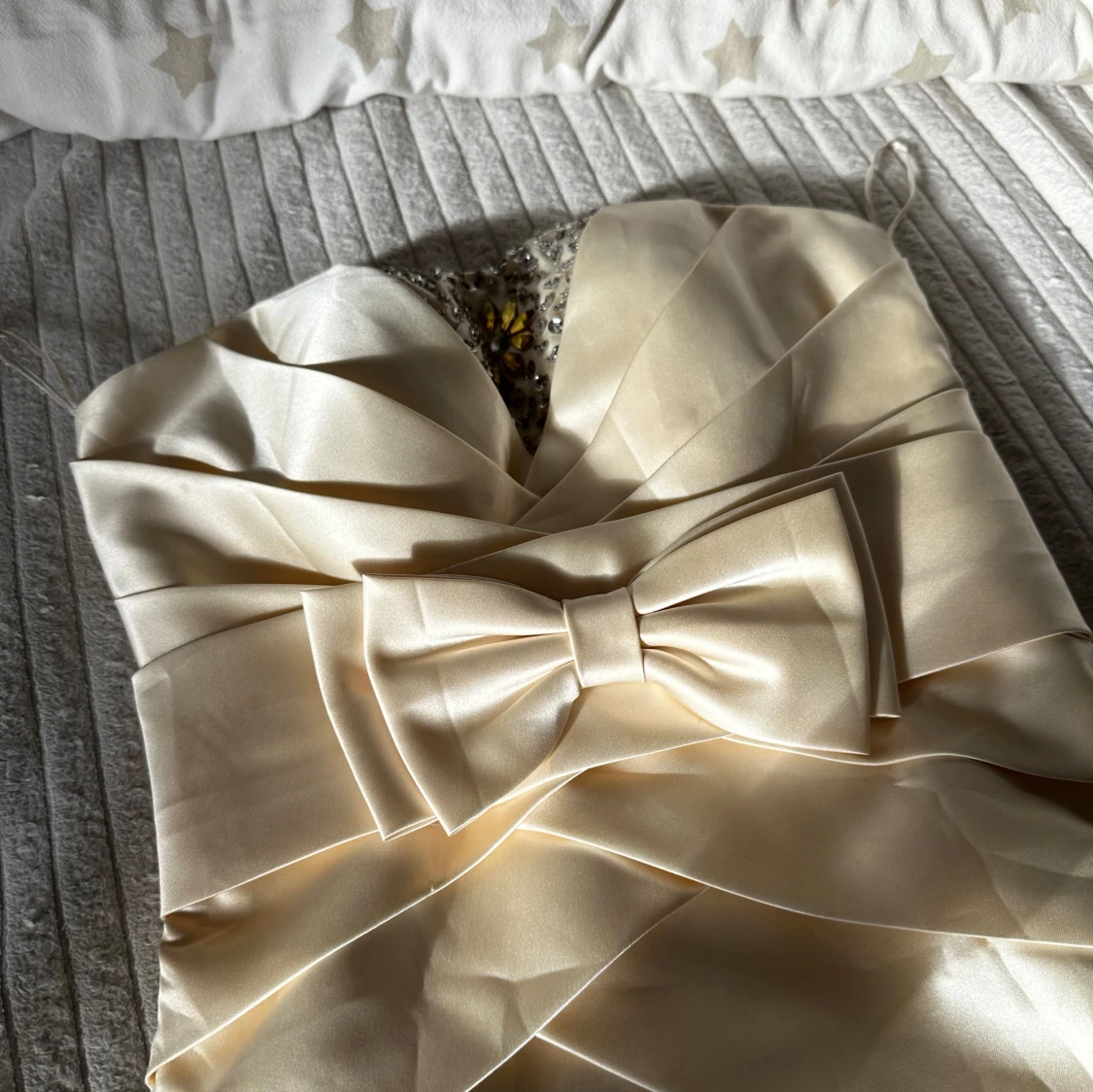 Beige kort klänning med rosett och pärldetaljer - 2