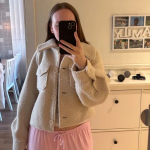Beige teddyjacka från NA-KD - Supermjuk och trendig beige teddyjacka från NA-KD med stora knappar framtill och två bröstfickor. Jackan är croppad och har en oversized passform 