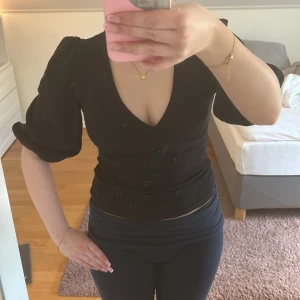 Svart topp med puffärm och v-ringning - Säljer super fin topp som tyvärr ej kommer till användning längre!
