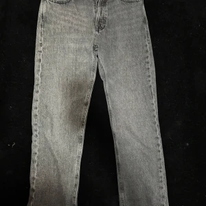 Grå jeansbyxor från Jack & Jones - Säljer ett par grå jeansbyxor från Jack & Jones i modellen Relaxed Chris. Byxorna har en avslappnad passform med raka ben, klassisk femficksdesign och stängs med dragkedja och knapp. Perfekta för en chill och stilren look.