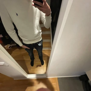 Vit crew neck Polo Ralph Lauren - Säljer en stilren vit sweatshirt från Polo Ralph Lauren med den klassiska broderade loggan på bröstet. Tröjan har rund halsringning och långa ärmar. Perfekt för en clean och enkel look.