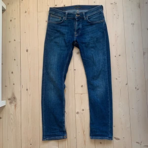 Nudie Jeans, Grim Tim, 31/30 - Hej, säljer nu detta par jeans från Nudie Jeans. Klassisk blå indigo-tvätt i riktigt bra skick med enbart lite slitning på höger bakficka. Storleken är 31/30 och i modellen Grim Tim. Hör av dig om du vill ha fler bilder eller har några frågor! 😁