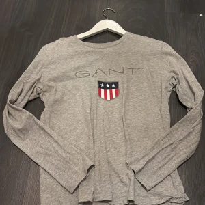 Grå långärmad tröja från GANT - Säljer en stilren grå långärmad tröja från GANT. Tröjan är aldrig använd och den är väldigt mjuk i tyget. Skulle säga att storleken är en S. 