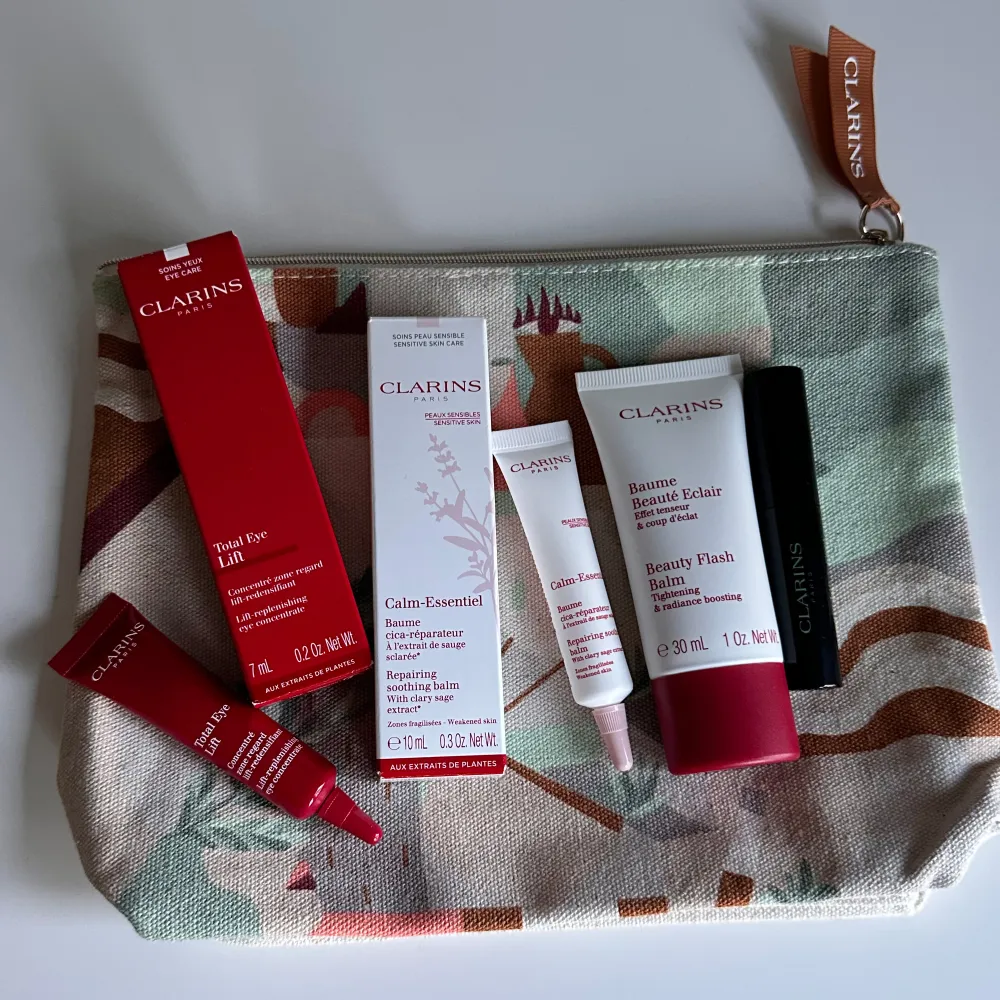 Ett skönhetsset från Clarins med en färgglad necessär. Innehåller Total Eye Lift, Calm-Essentiel Restoring Treatment Oil, Beauty Flash Balm och en mascara. Perfekt skönhetsrutin.. Beauty.
