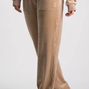 Beige juciy couture  - Snygga juciy byxor i beige med guld detaljer.       . !obs! Skicka pm för egna bilder! Inte använda många gånger. Kan ha lite lite missfärgning längst ner på benen typ 4-5 cm max inte synligt när man använder pga dom är lite långa på mig som är 158cm