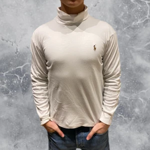 Ralph Lauren Soft Cotton Roll Neck Tröja Vit - •Ralph Lauren Soft Cotton Roll Neck tröja vit. Riktigt snygg & fräsch tröja som har bekvämt material! (Inte T-shirt material, tjockare!). Skick: 8-9/10, Inga skador! Storlek: M, fits S. liten i storlek så sitter som en S. Modell: 173 cm, 63 kg. Authentic: ✅, qr kod finns i plagget. Nypris: 1 600 kr! Hör av dig vid frågor eller funderingar, mvh Hessler’s;)