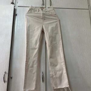 Beige jeans från Primark - Snygga beige jeans från Primark med hög midja och fransiga kanter. Perfekta för en avslappnad stil. Tillverkade i ett bekvämt denimtyg.