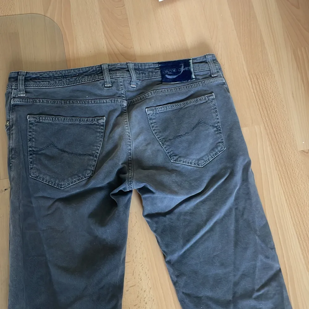 Snygga grå jeansbyxor från Jacob Cohen med klassisk femficksdesign och knappar i gylfen. Byxorna har raka ben och diskreta sömmar på bakfickorna. Perfekta för en stilren och avslappnad look. Det är W36 men de är små i storleken passar mig som har W32/33 Priset går att diskuteras.. Farkut & Housut.