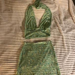 Set kjol och halterneck topp med knytning - säljer detta fina set! kjolen har resår i midjan. båda delarna är i stretchigt material. toppen har knytning i nacken. OBS toppen är i strl s, kjolen är i strl xs