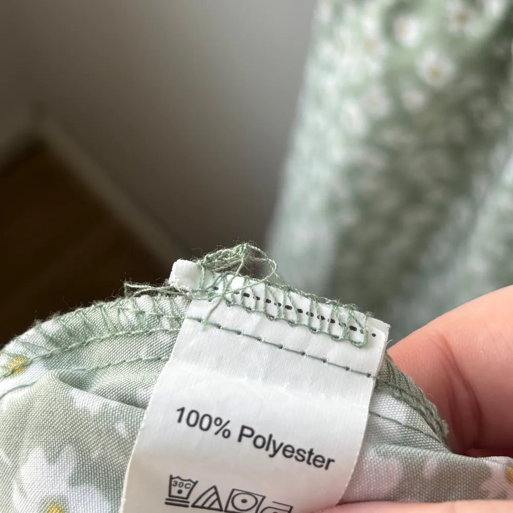Söt grön klänning med vita blommor från Shein.   Ärmar med volangdetaljer. Är resår i midjan. Svårt att få med hela på bild men om det önskas kan bild i dm skickas. För referens är jag 1,57 och denna går ner till strax innan mina knän. Som synes är knäppet bak sönder men för den händige går det att ersätta. . Mekot.