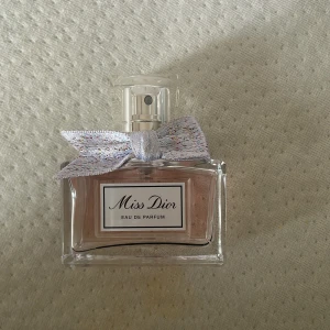 Miss Dior Eau de Parfum 30 ml - Miss Dior Eau de Parfum i elegant glasflaska med ljusrosa doft och en dekorativ silvrig rosett vid halsen. Parfymen kommer i en stilren vit kartong med silverdetaljer och rymmer 30 ml. har använt den fåtal gånger (se bild 2) säljer för jag inte tycker doften passar mig men det är en klassisk och feminin doft från Dior.