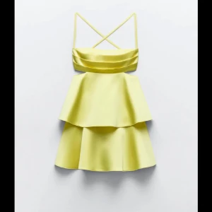 Ljusgul kort klänning med volanger och smala axelband - Superfin ljusgul klänning i satin. Klänningen har en öppen rygg och kort design som ger den en somrig känsla. Skriv privat för frågor eller egna bilder💛