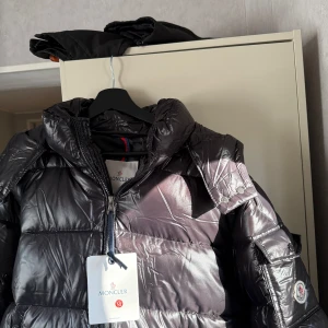 Svart dunjacka från Moncler - Säljer en snygg svart dunjacka från Moncler med glansig finish. 