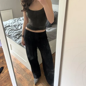 Svarta lågmidjade kostymbyxor - Säljer ett par svarta kostymbyxor med Lågmidjade skimmer. Byxorna har lågmidja raka vida ben och klassisk passform. Perfekta för dig som vill sticka ut lite extra med en stilren look. Säljer dessa då de är en aning för stora för mig! Verkligen super snygga! Prislapp kvar