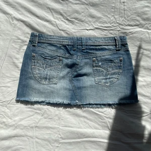 Minikjol - Supersnygg kort jeanskjol med broderade fickor.  midja: 41 cm längd fram: 26 cm längd bak: 28 cm