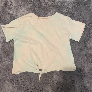 Kortärmad t-shirt med knyt - Säljer en kortärmad t-shirt med knyt framtill. Från HM i storlek 140