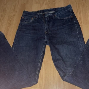 Mörkblå jeans från Levi's - Säljer ett par klassiska mörkblå jeans från Levi's. De har en rak passform och är tillverkade i slitstarkt denim. Perfekta för en avslappnad stil.