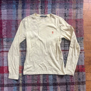 Gul långärmad tröja från Ralph Lauren Sport - Säljer en stilren gul långärmad tröja från Ralph Lauren Sport med det klassiska röda passar storlek s logotypbroderiet på bröstet. Perfekt för en avslappnad och snygg look. Tröjan är i mjukt bomullsmaterial och har en rund halsringning.