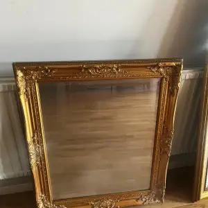 En guldfärgad spegel i stl 65x75