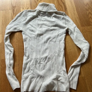 Vit ribbad polotröja från Atmosphere XS - Säljer en stilren vit ribbad polotröja från Atmosphere. Tröjan har en klassisk polokrage och långa ärmar, perfekt för kyligare dagar. Den är både bekväm och snygg, ett måste i garderoben! 🌟Nyskick!