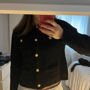 Svart cardigan jacka med guldknappar - Snygg svart cardigan jacka med guldknappar framtill. Passar både till finare tillfällen och till vardags. Så lyxig! Säljer direkt för 200kr+frakt. 