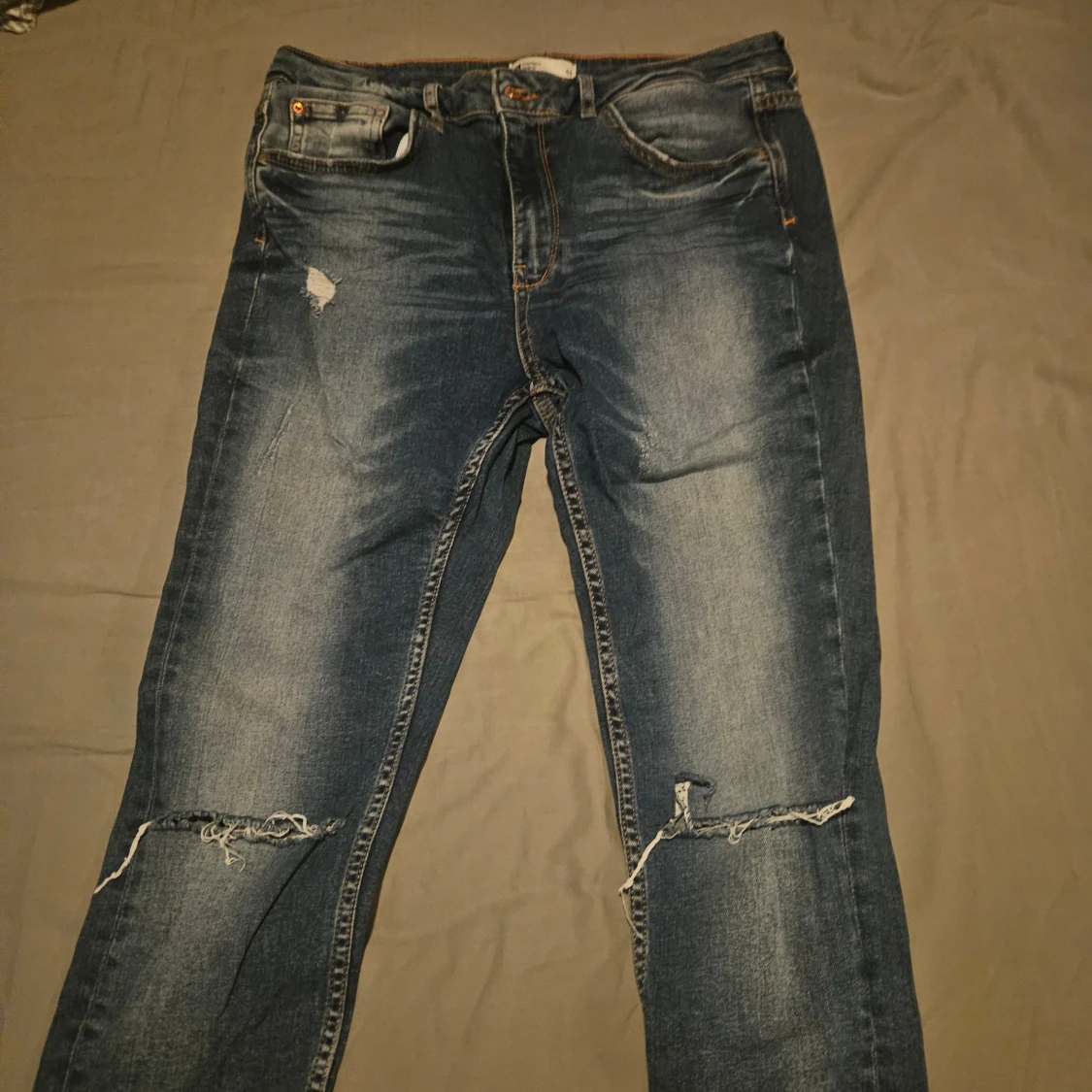 Blå jeans med slitningar