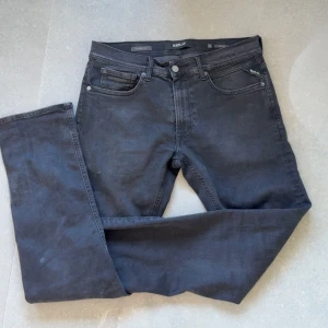 Svarta jeans från Replay - Snygga svarta jeans från Replay, modell Grover. De har en klassisk femficksdesign och en knappgylf. Perfekta för en stilren look. Storlek 31/32