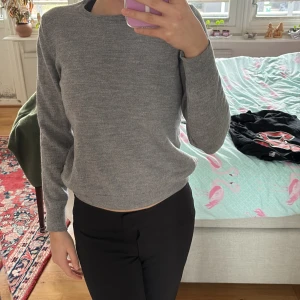 Grå tröja från NN07 - Säljer en stilren grå tröja från NN07. Tröjan har en klassisk design med långa ärmar och rund hals. Perfekt för en avslappnad och snygg look.