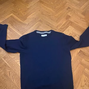 Mörkblå tröja från Pier One - Säljer en stilren mörkblå tröja från Pier One. Tröjan har  en rund halsringning med vita ränder på insidan av kragen. Perfekt för en avslappnad look. Ny pris 280. Mitt pris 150 Inget är trasig på tröjan den är som ny