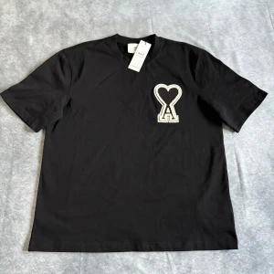 Ami t-shirt - Säljer en svart t-shirt från Ami. T-shirten är stilren och passar till de mesta! Den är helt oanvänd med prislapp som sitter kvar. Priset går att diskutera. Hör av dig vid fler frågor eller funderingar!