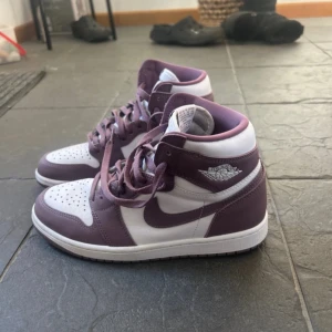 Nike Air Jordans i lila och vit - Snygga Nike Air Jordans i en stilren kombination av lila och vit. Skorna har klassisk snörning och den ikoniska Air Jordan-loggan på sidan. Perfekta för dig som vill ha en sportig och trendig look. Säljer då dom va fel storlek för mig💗 köpts i usa så storleken står i us 8 men är eu 40 orginalpris= ca 1600kr