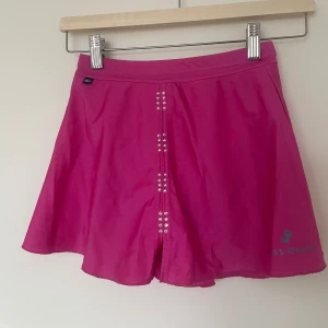 Rosa kjol från Passionice - Fin rosa konståkningskjol från passionice! Den har kristaller framtill och innertrosa. Storlek 142. Fint skick och går ej att köpa från hemsida. 💕