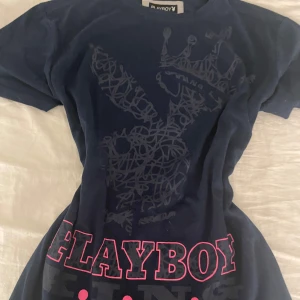 2000s Vintage Playboy t-shirt - Snygg mörkblå t-shirt från Playboy med ett coolt tryck av en kanin med en krona och texten 'PLAYBOY' i rosa. Gjord av en skön blandning av bomull och polyester. Män storlek S men passar även tjejer S/M/L 