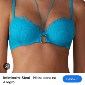 Turkos bh med spetsdetaljer från Intimissimi - Säljer en turkos bh från Intimissimi med dekorativa sömmar och spetsdetaljer upptill. Bh:n har en unik design med extra band framtill och metallring i mitten. Perfekt för dig som vill ha något snyggt och annorlunda. Passar 75a och 75b