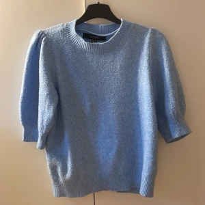 Ljusblå stickad tröja från Vero Moda - Superfin ljusblå stickad tröja från Vero Moda med puffärmar och ribbade muddar. Tröjan har en croppad passform och rund halsringning. Perfekt för lager-på-lager och enkel att styla till olika outfits.