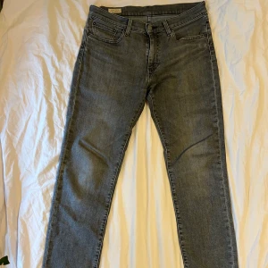 Levi's 511 grå jeans - Säljer ett par grå Levi's 511 jeans i storlek W31 L34. Klassisk femficksmodell med dragkedja och raka ben. Snygg passform som sitter bekvämt och funkar till många olika stilar. Perfekta för dig som gillar tidlösa jeans.