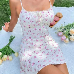 Vit blommig kortklänning - Söt vit kortklänning med små rosa blommor och tunna axelband. Oanvänd 