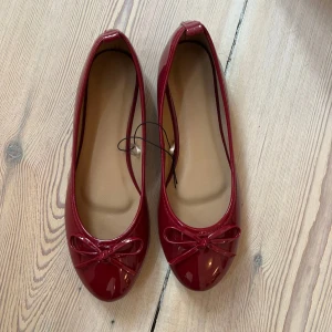 Röda ballerinaskor med rosett - Slutsålda ballerina skor från design by si, helt oanvända och kommer i original förpackningen!