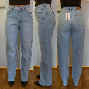Ljusblå raka jeans från NA-KD - Säljer ett par ljusblå jeans från NA-KD med raka ben. Jeansen har hög midja och är aldrig använda. Prislappen sitter kvar!!  Hör av er vid frågor 🌟💗