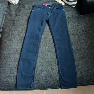 Levi's 510 Skinny jeans i mörkblå denim - Säljer ett par Levi's 510 Skinny jeans i mörkblå denim. Byxorna har klassisk femficksdesign, smal passform från höft till ankel och stretchigt material för extra komfort. Perfekta för dig som gillar en modern look.