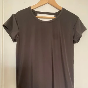 Mörkgrå omlott-t-shirt - Stilren mörkgrå t-shirt med omlott-design baktill. 